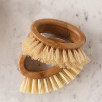 2: Oval-shaped handheld kitchen brushes on a marble countertop