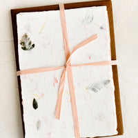Large / Floral: Handmade flower petal paper and kraft envelopes bound with peach ribbon.