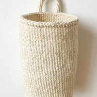 Cream: An oblong cylindrical basket woven from sisal in cream color.