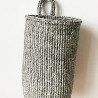 Slate: An oblong cylindrical basket woven from sisal in slate color.