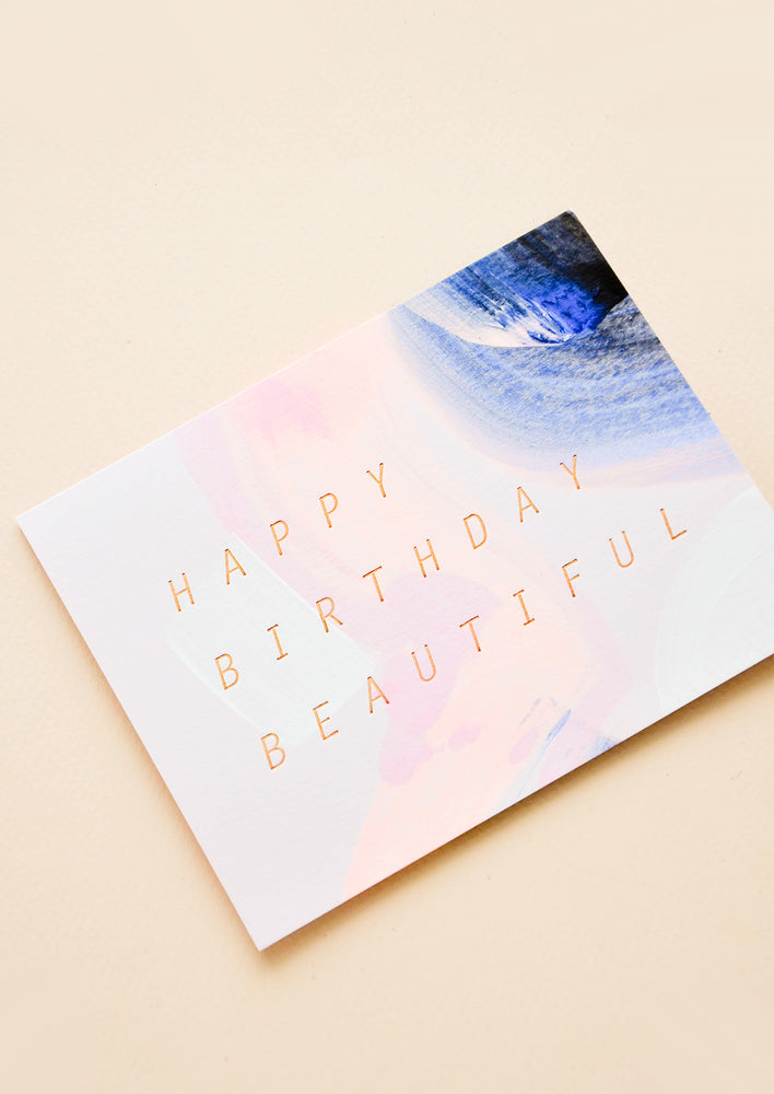 Greeting card with blue and pink brushstrokes and "Happy Birthday Beautiful" in copper foil.