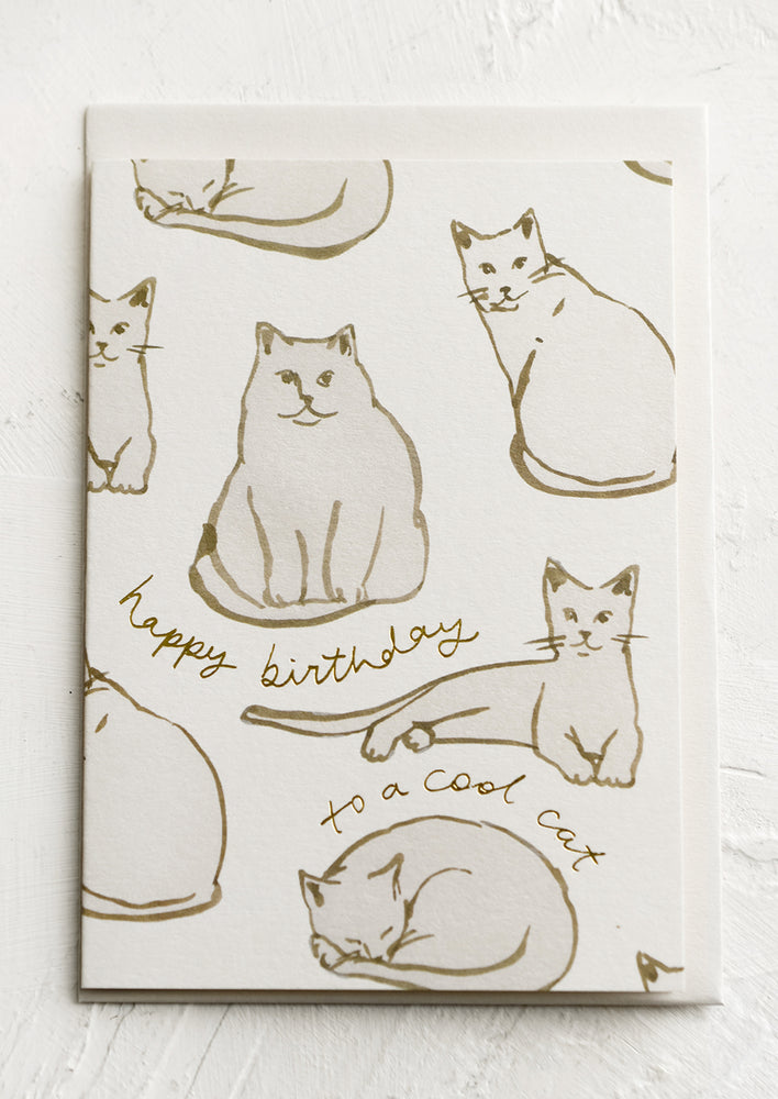 A birthday card with cat illustrations and gold text.