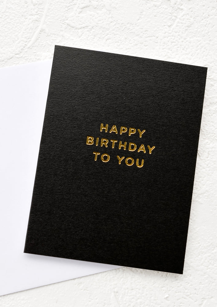 1: Black greeting card with gold lettering reading "Happy birthday to you"