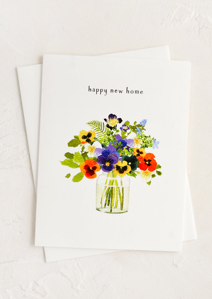 A greeting card with bouquet of flowers in a vase and text at top reading "happy new home".