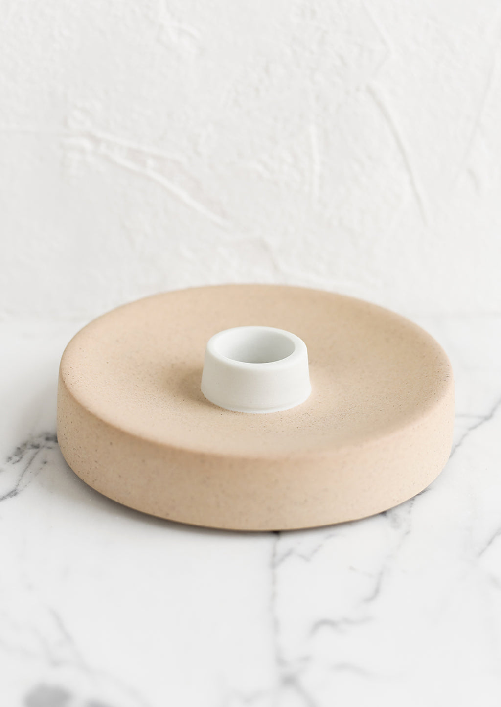 Single / Sand / White: A round ceramic taper candle holder in sand.