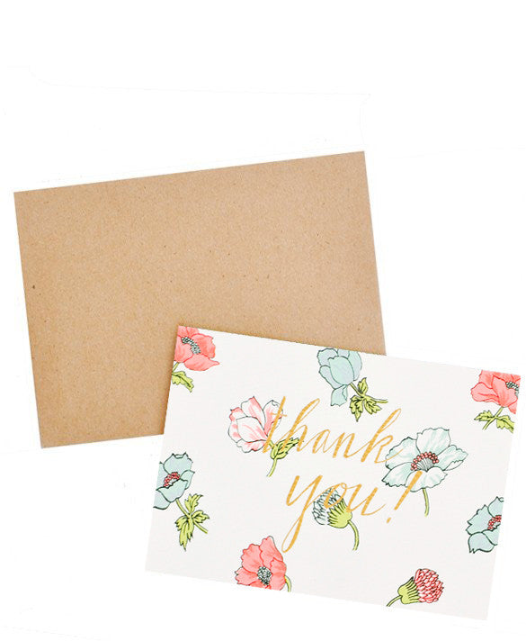 2: Notecard with neon flowers and the text "Thank you!" in gold foil, with brown envelope.