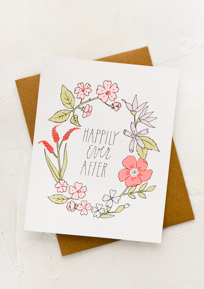 An illustrated greeting card with floral wreath surrounding text reading "Happily ever after".