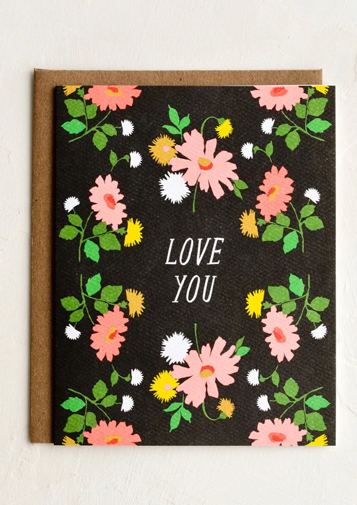 A black greeting card with "LOVE YOU" printed at center surrounded by flowers.