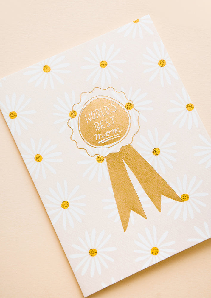 1: Greeting card with allover daisy pattern and gold ribbon reading "World's Best Mom" 
