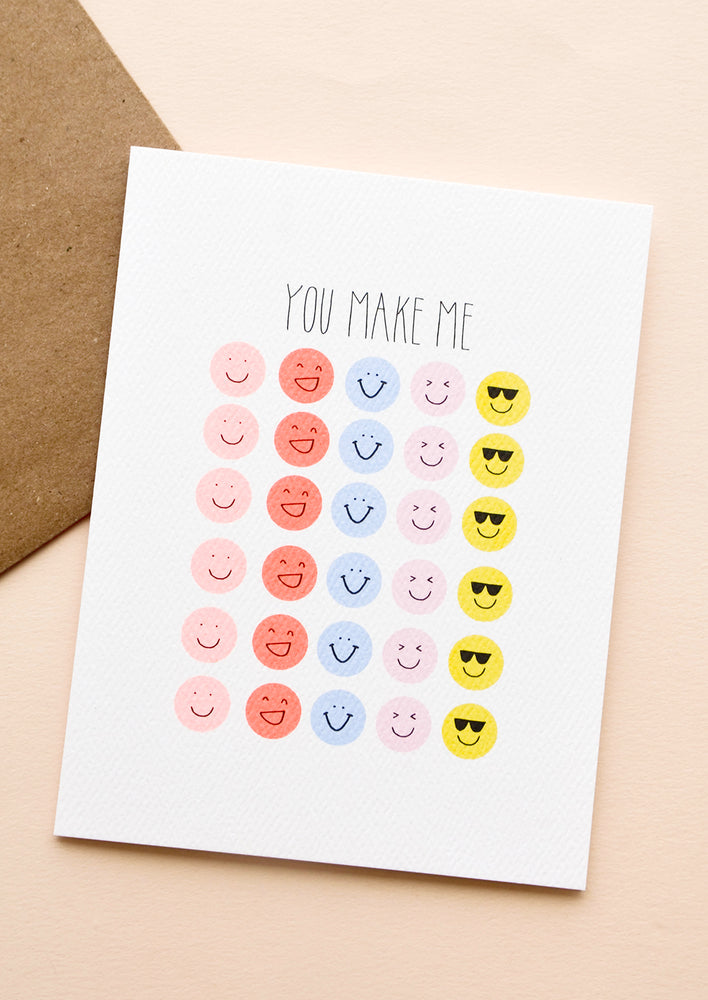 1: Greeting card with text reading "You Make Me", rows of various emojis printed below