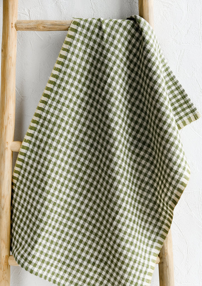 A woven gingham linen tea towel in olive green color.
