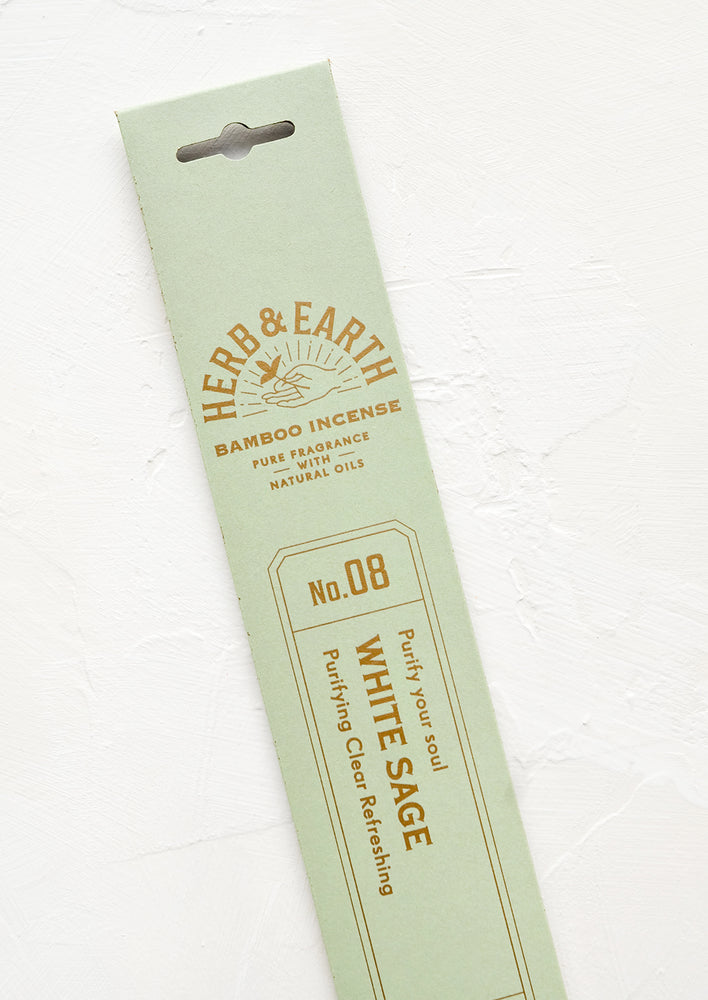 A mint green packaging sleeve containing sage scented incense.