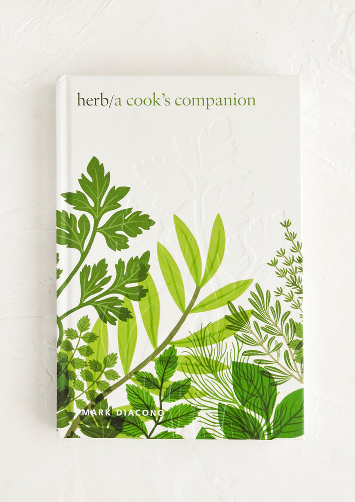 Hardcover cookbook with digital herb imagery.