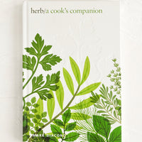 1: Hardcover cookbook with digital herb imagery.