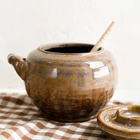 2: A brown ceramic honey jar.