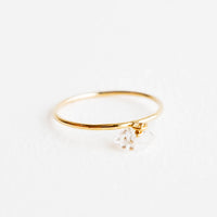 1: Slim yellow gold ring with a dangling white faceted stone.