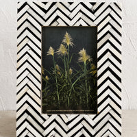 1: A bone picture frame with black and white chevron pattern.