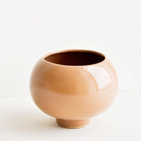 1: A ceramic planter in round shape with footed base and a glossy cocoa brown finish.