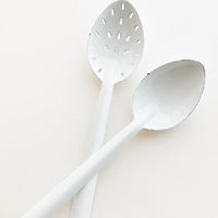 2: One regular and one slotted white enamel spoon.