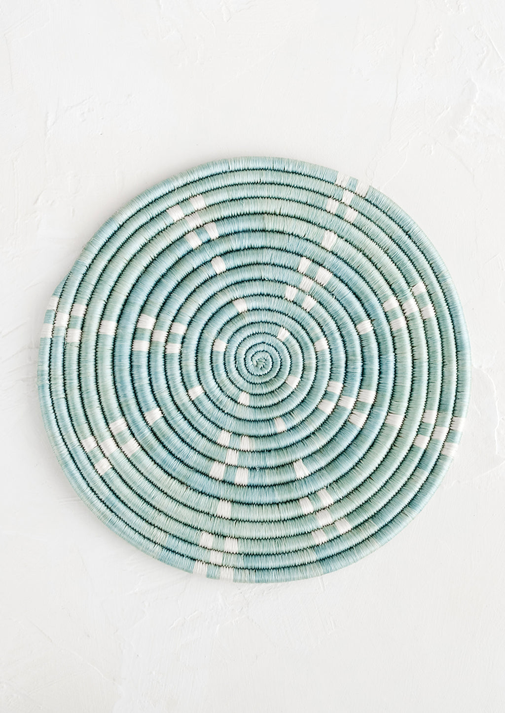 Lake Blue: A round sweetgrass trivet in blue with white dash pattern.
