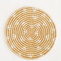 Toasted Almond: A round sweetgrass trivet in tan with white dash pattern.