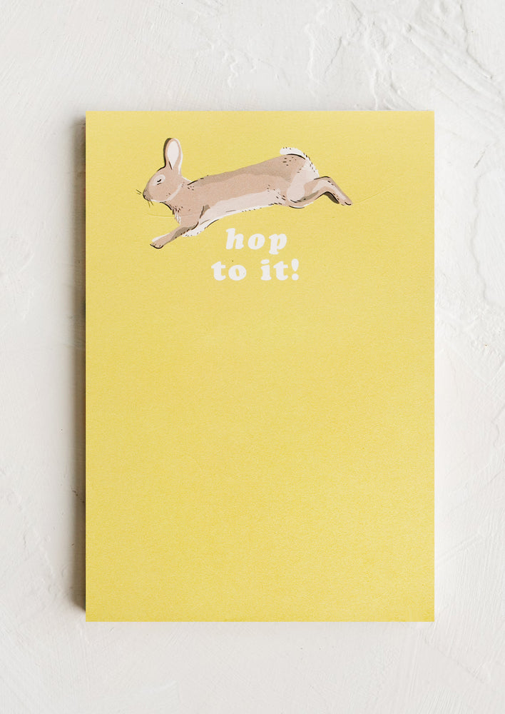 A yellow unruled notepad with image of bunny at top.
