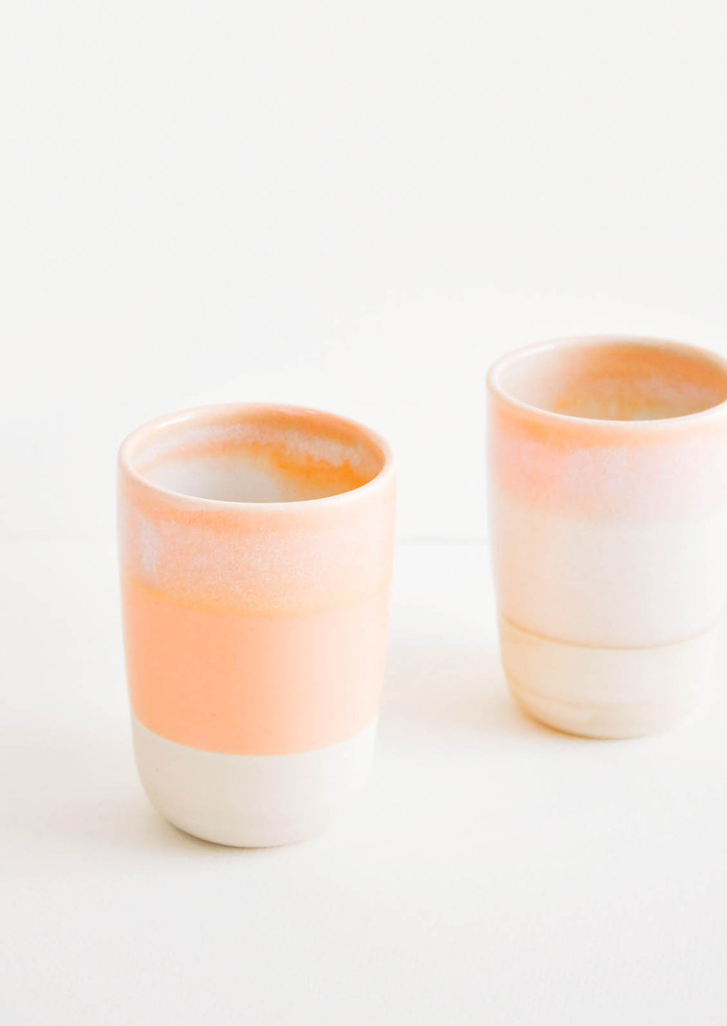 Sunset Dip: Two ceramic tumblers with unfinished bottoms and orange glaze.