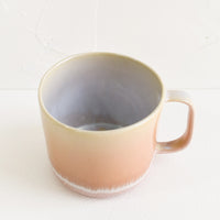 2: A ceramic mug in peach with ombre glaze.