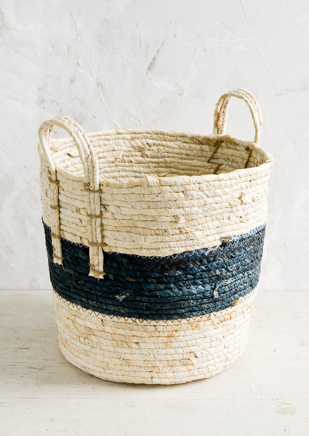 1: A storage basket with two top handles, woven from natural fiber.