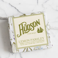 Lemon Parsley: A square bar of soap in botanical printed packaging in Lemon Parsley scent.