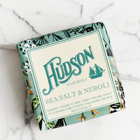 Sea Salt & Neroli: A square bar of soap in botanical printed packaging in Sea Salt & Neroli scent.
