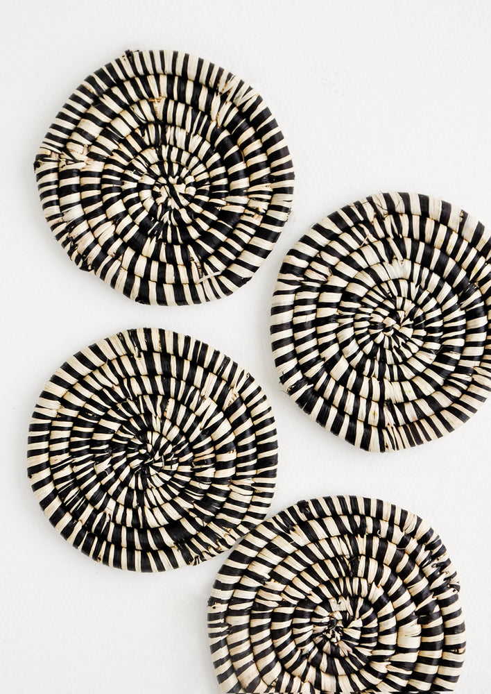 Black: Set of 4 Round Woven Raffia Coasters in Black and natural stripe.