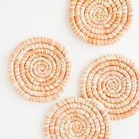 Peach: Set of 4 Round Woven Raffia Coasters in Peach and natural stripe.