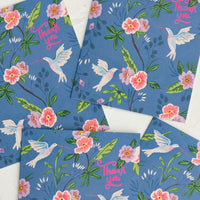 1: A set of blue greeting cards with hummingbird floral print, pink script at corner reads "Thank you".