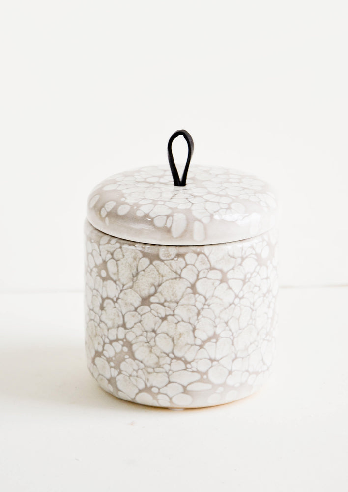 Ceramic storage jar in bubbly, glossy grey glaze with black leather pull on lid