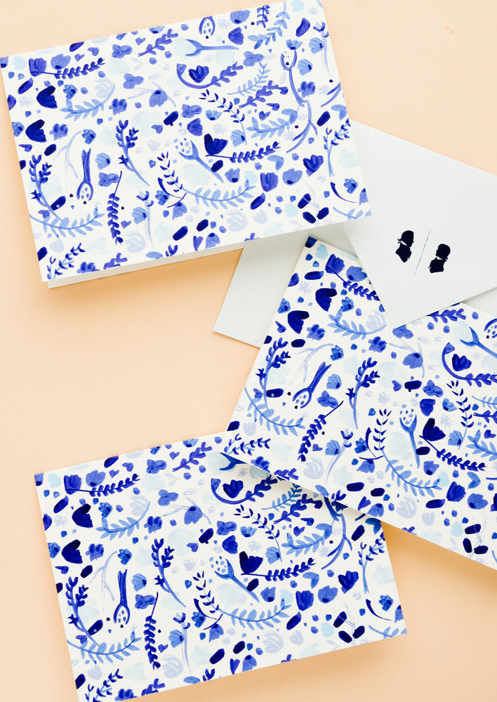 1: A set of identical greeting cards with white and blue watercolor floral print.