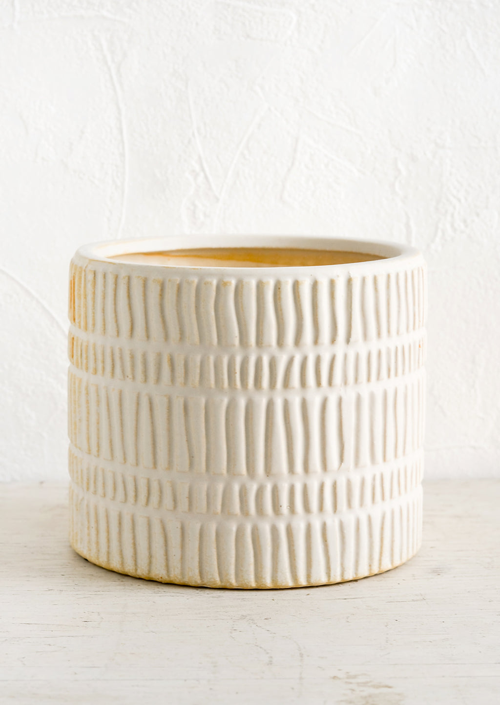 Large: A bisque ceramic planter with rows of raised line texture throughout.