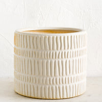 Large: A bisque ceramic planter with rows of raised line texture throughout.