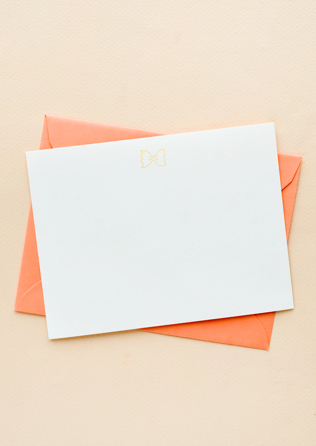 Bowtie Pasta: A coral colored envelope with white notecard and small icon of a piece of bowtie pasta printed at top.