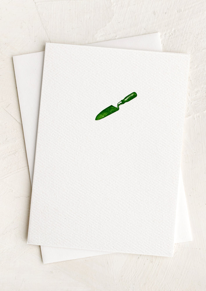 A plain white card with small green trowel at front.