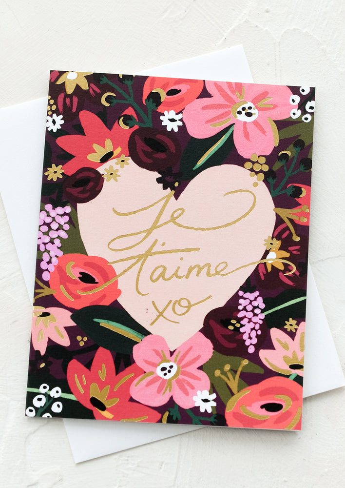 A floral print card reading "Je taime" in gold script.