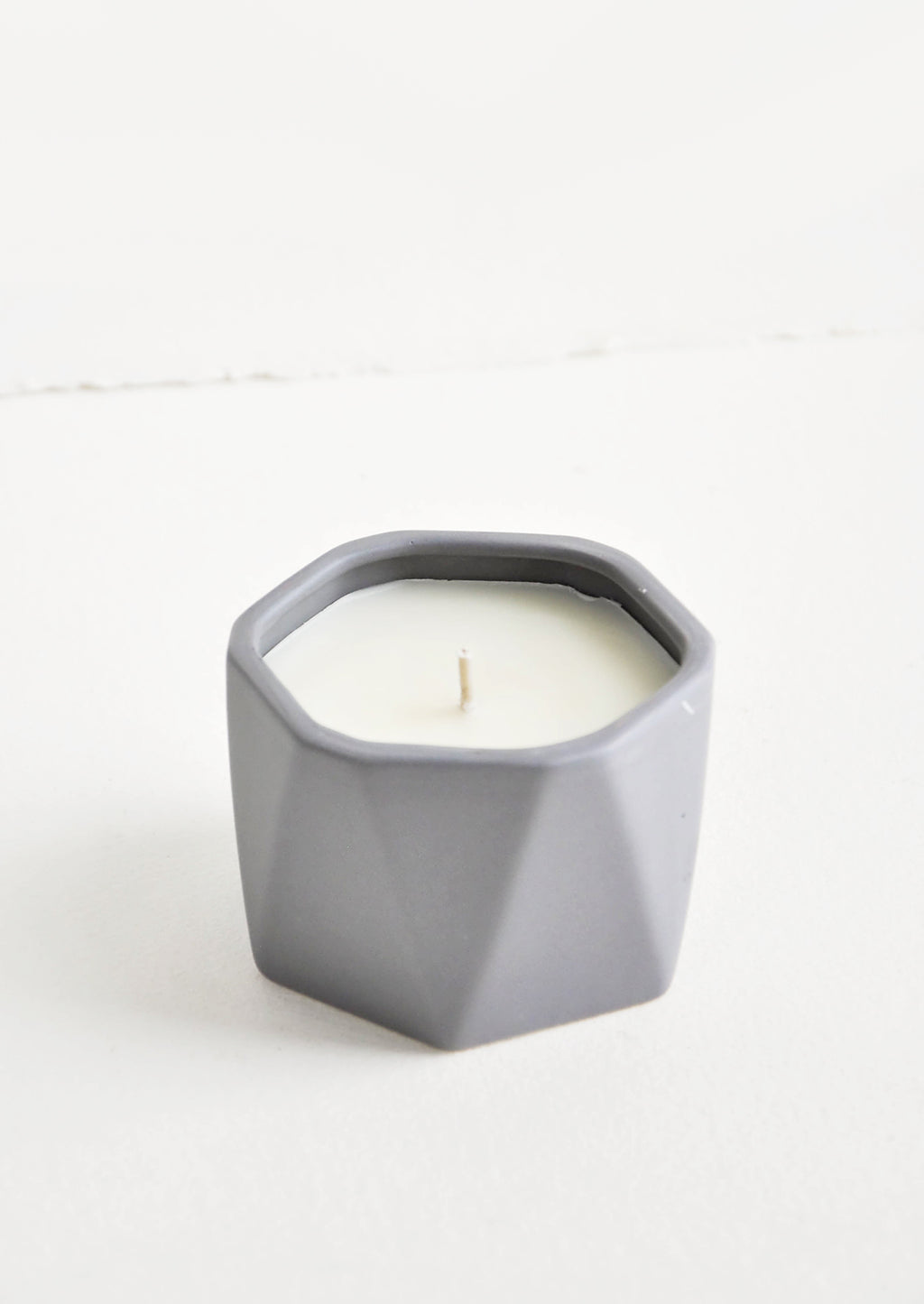 Blackberry Absinthe: A small candle in dark grey faceted ceramic vessel.