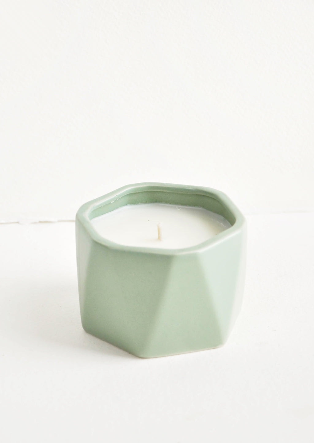 Santal Fig: A small candle in green faceted ceramic vessel.