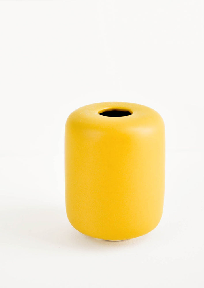 1: Small, tubular shape ceramic bud vase in matte mustard