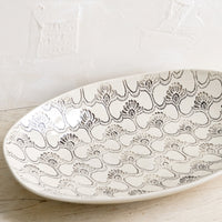 Large: A large oval shaped ceramic platter with black and white textile pattern.