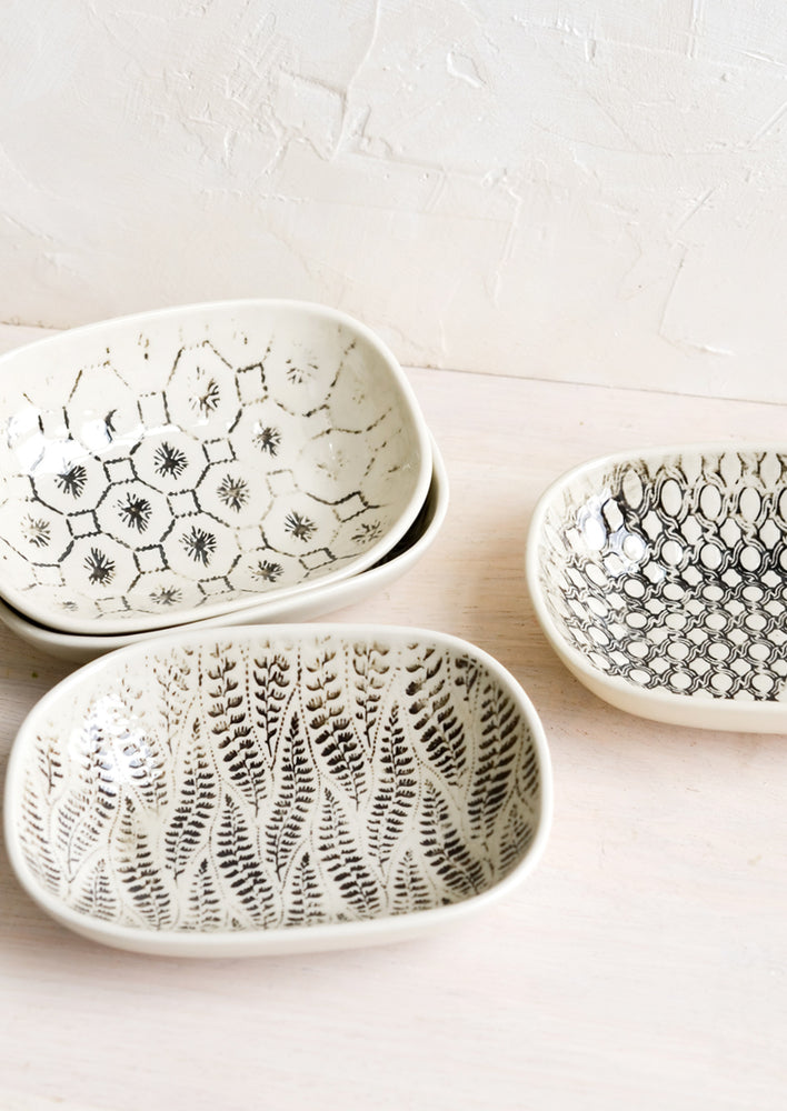 1: Small oval ceramic dishes in assorted black and white patterns.