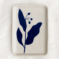 Small: A white ceramic tay with blue floral print.