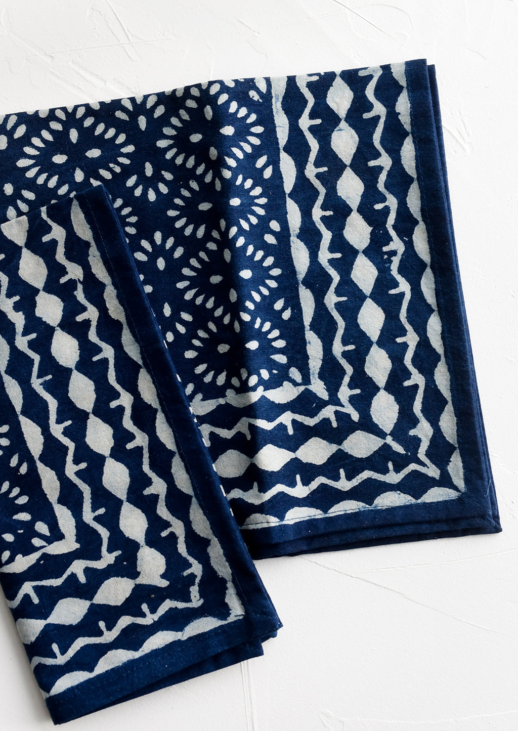 2: A pair of indigo napkins with white block printed pattern.