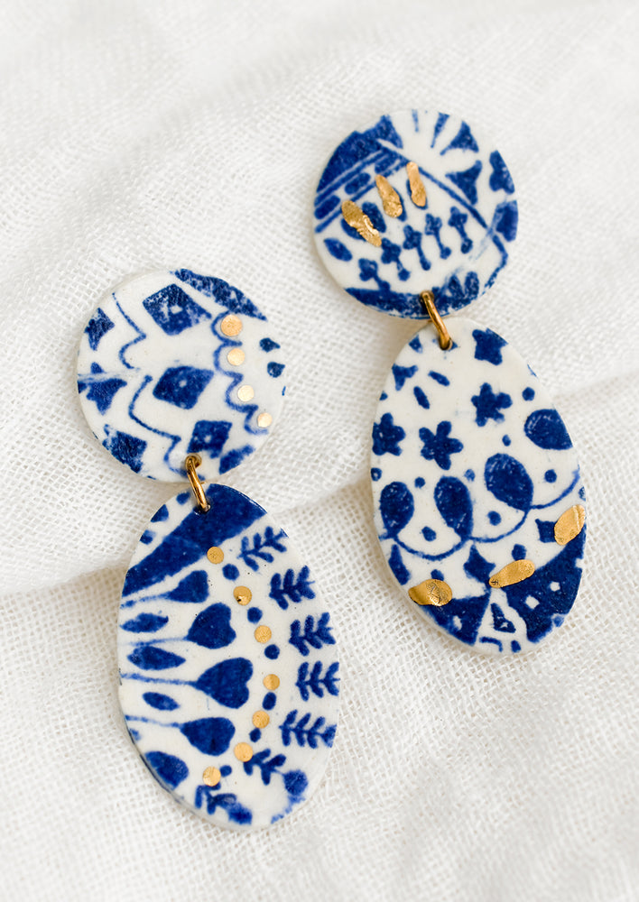 1: A pair of two-part ceramic earrings with indigo and gold leaf pattern.