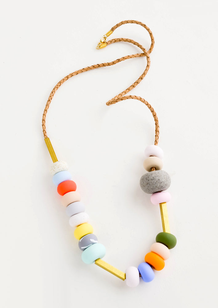 Necklace featuring round clay beads in a mix of colors and sizes strung on leather cord